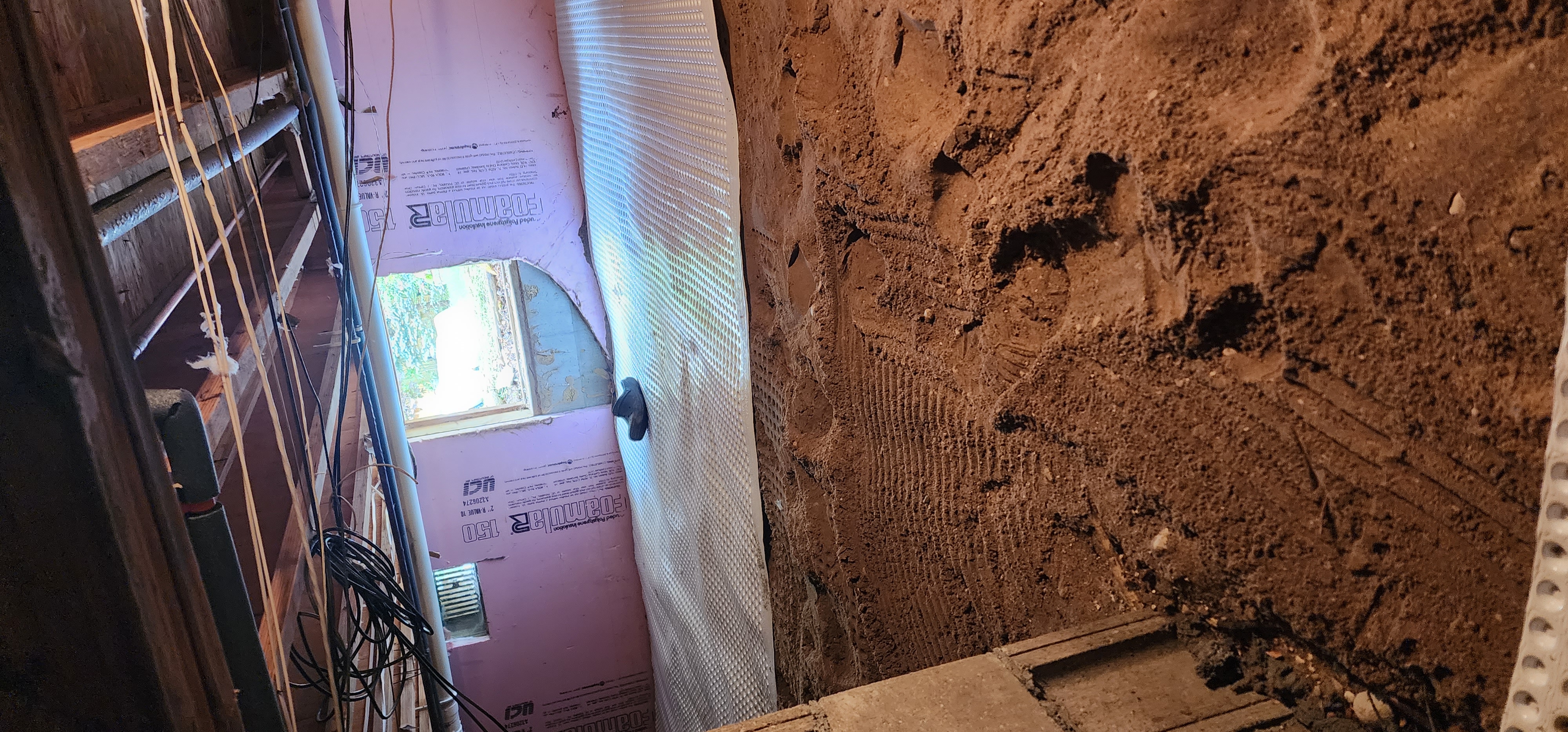 Crawlspace encapsulation process showing vapor barrier installation