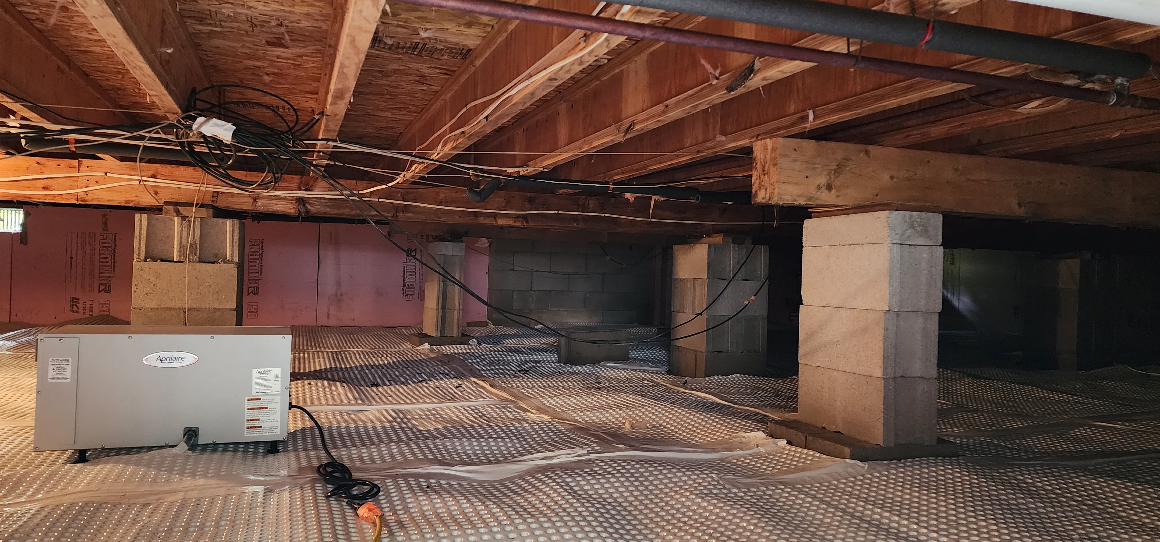 A crawlspace undergoing encapsulation with a professional team in Remus, Michigan.