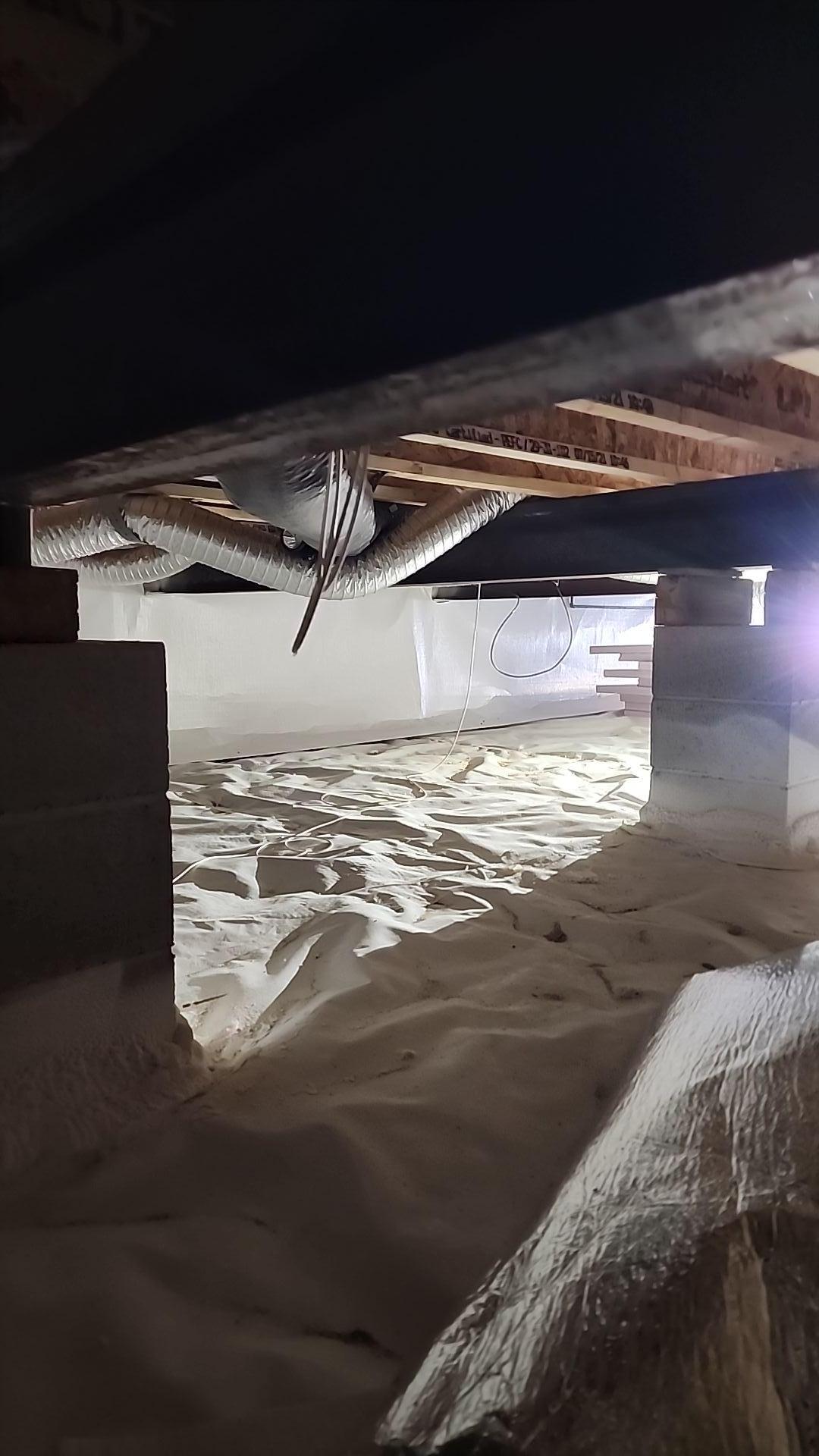 Crawlspace encapsulation process in a Manton, Michigan home, showing sealing and application.